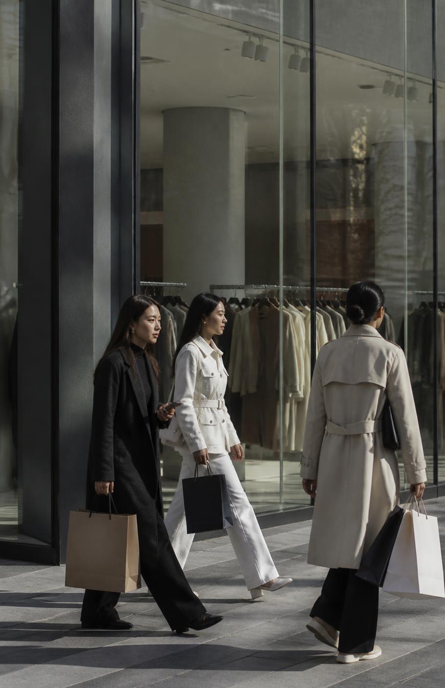 Shoppers with bags walking past a contemporary retail storefront in Central Asia